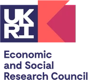 Eine Wissenschaftlerin und ein Wissenschaftler arbeiten hinter einer Glasfassade und mischen Chemikalien mit Großgeräten.